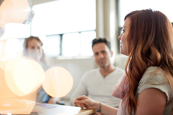 Candid picture of a business team collaborating. Filtered serie with light flares, bokeh  and warm sunny tones.